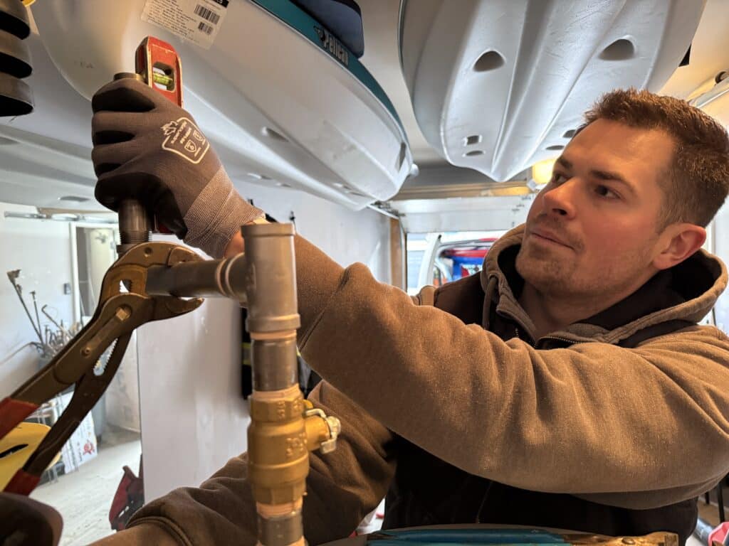 Plumber in Calgary installing a boiler and hydronic heating system